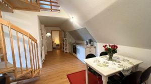 a kitchen with a table with a vase of flowers on it at Hof Döttgebüll in Aventoft