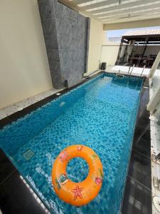 a large swimming pool with an orange raft in it at Zahret Al Roman in Sayq