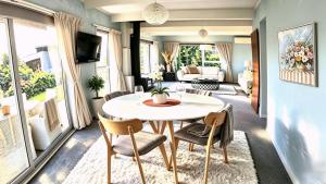 a living room with a table and chairs at Clifftop Coastal Retreat with Ocean Views - Close to Beach & Cafés in Auckland