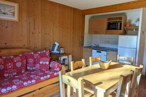 a kitchen and dining room with a couch and a table at Chalet MÖKI accès piscine sauna in Les Déserts +15 photos