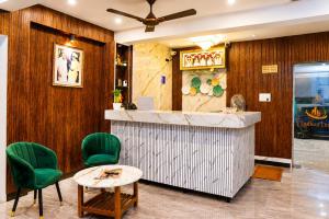 a restaurant with green chairs and a counter at Raja's Paradise Inn in Chennai