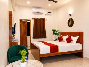 a bedroom with a bed and a table and chairs at Raja's Paradise Inn in Chennai