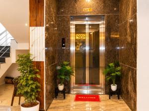 an elevator lobby with potted plants in a building at Raja's Paradise Inn in Chennai +11 photos