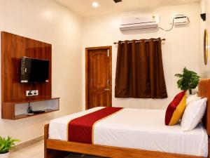 a hotel room with a bed and a television at Raja's Paradise Inn in Chennai
