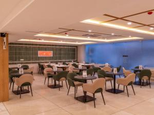 a dining room with tables and chairs in it at The Hosteller Gurgaon in Gurgaon