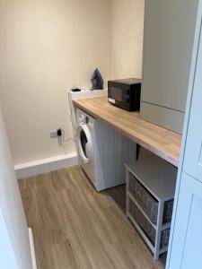 a laundry room with a washer and a microwave at Tudor House in Osgodby
