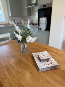 a vase of flowers on a table with a book at Tudor House in Osgodby +23 photos