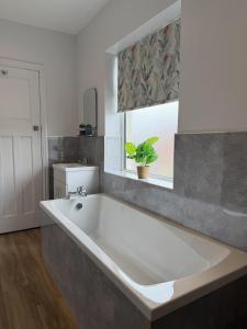a large bath tub in a bathroom with a window at Tudor House in Osgodby