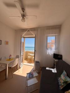 a living room with a couch and a table at Apartament Mare e Sole z basenem i przy plaży in Marotta