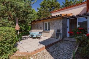 a patio with a table and chairs in front of a house at Les Issignols - Chambre d'hotes in Colombier-le-Vieux