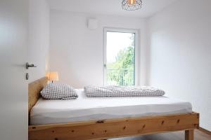 a bed in a room with a window at Ferienwohnung Bodensee 2 in Meßkirch