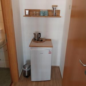 a small kitchen with a white refrigerator and a counter at Pension am Bernsteinmuseum - Doppelzimmer in Ribnitz-Damgarten