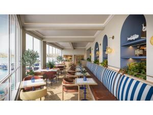 a restaurant with tables and chairs and windows at Elysium St Mawes in Saint Mawes