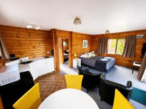 a living room with a bed and a dining room at Forest Peak Motel in Hanmer Springs +16 photos