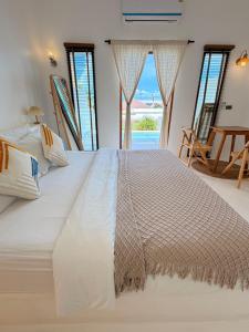 a large white bed in a room with windows at Kamari Cafe&Resort Kohlarn คามารีคาเฟ่แอนด์รีสอร์ทเกาะล้าน in Ko Larn +105 photos