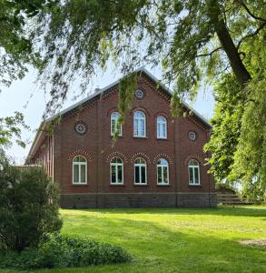a large red brick building with white windows at Gut Osterhausen in Butjadingen