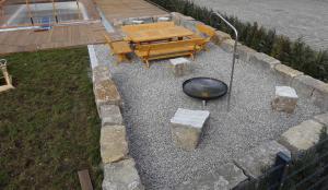 a patio with a grill and a table and a fire pit at Caseti 5 Ferienwohnungen - Rothenburg u Bad Windsheim in Oberdachstetten
