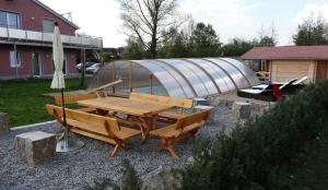 a picnic table with a tent and an umbrella at Caseti 5 Ferienwohnungen - Rothenburg u Bad Windsheim in Oberdachstetten