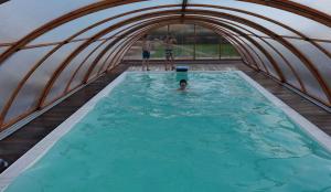 two boys standing in a swimming pool in an igloo at Caseti 5 Ferienwohnungen - Rothenburg u Bad Windsheim in Oberdachstetten