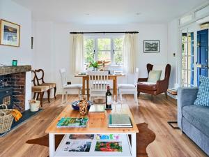 a living room with a couch and a table at Finest Retreats - Coachmans Cottage in Lapford