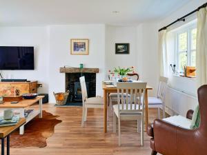a living room with a table and a fireplace at Finest Retreats - Coachmans Cottage in Lapford