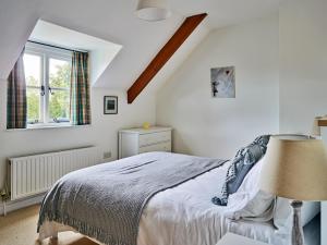 a bedroom with a bed and a window at Finest Retreats - Coachmans Cottage in Lapford