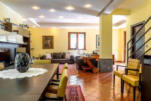 a living room with a couch and a table at Villa Corte Fiorita in Aci SantʼAntonio