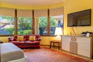 a bedroom with a couch and a flat screen tv at Villa Corte Fiorita in Aci SantʼAntonio