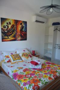 a bed in a bedroom with two paintings on the wall at La Salamandre 66 in Saint-Génis