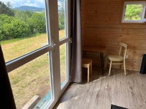 a room with a window and a table and chairs at Samoobslužná maringotka in Žihobce