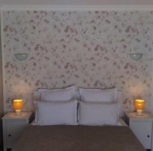 a bedroom with a bed with two lights on the wall at la grange du coudert in Saint-Cybranet