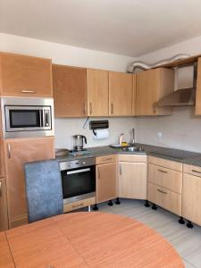 a kitchen with wooden cabinets and a stove top oven at Apartman Enigma II in Ruma