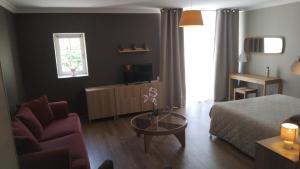 a living room with a bed and a couch and a table at la grange du coudert in Saint-Cybranet