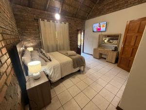 a bedroom with a bed and a brick wall at The Willows in Polokwane
