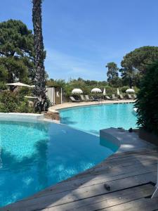 a swimming pool with blue water and umbrellas at Kilina in Porto-Vecchio