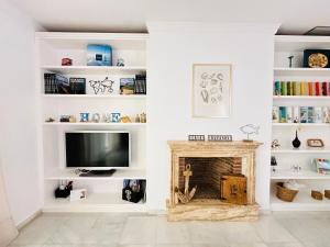 a living room with a fireplace and a tv at Casa Bluende in Novo Sancti Petri