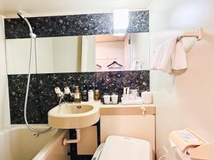 a small bathroom with a sink and a toilet at HOTEL LiVEMAX BUDGET Nippori in Tokyo
