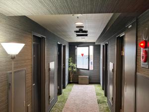 a hallway of an office building with a walkway at HOTEL LiVEMAX BUDGET Nippori in Tokyo