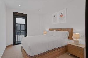 a bedroom with a large white bed and a window at GAV Nueva Quince in Ronda