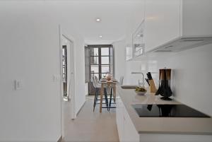 a white kitchen with a counter and a table at GAV Nueva Quince in Ronda +92 photos