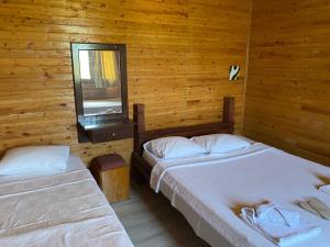 two beds in a wooden room with a window at Magic Camp&Bungalow in Fethiye +7 photos