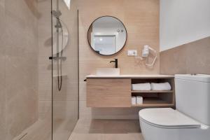 a bathroom with a toilet and a sink and a mirror at GAV Nueva Quince in Ronda