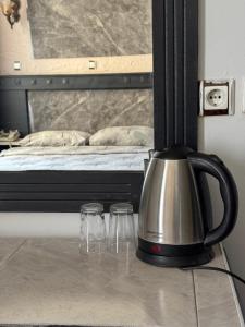 a tea kettle on a table next to a bed at Antik Otel in Ankara +47 photos