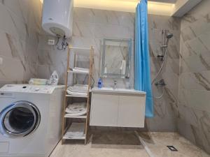 a bathroom with a washing machine and a sink at Teal Apartment in Draç +5 photos