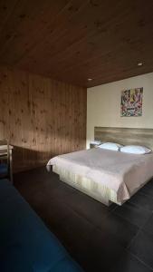 a bedroom with a large bed with wooden walls at Хутір Hall in Radisne