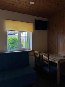 a room with a table and a couch and a window at Хутір Hall in Radisne
