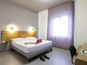 a bedroom with a bed and a desk and a window at Ibis Styles Brindisi in Brindisi