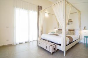 a bedroom with a four poster bed with curtains at Pietra Bianca Marzamemi in Marzamemi