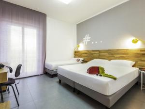 a hotel room with two beds and a desk at Ibis Styles Brindisi in Brindisi +50 photos