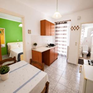 a kitchen with a sink and a table in a room at Sunset Apartments in Missolonghi
